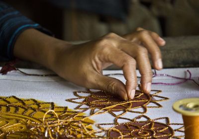 Cropped hand of woman working on table