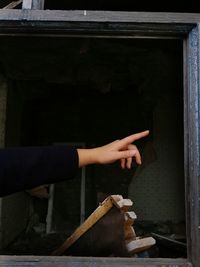 Cropped hand of woman pointing at home