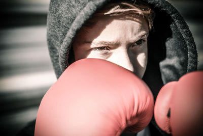 Boy wearing boxing glove while standing outdoors