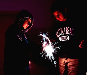 Man holding illuminated light painting at night