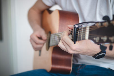 Midsection of man playing guitar