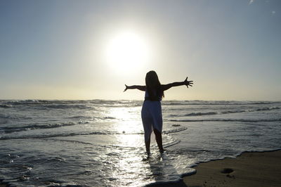 Silhouette of woman standing on beach