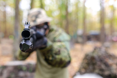 Soldier aiming gun in forest