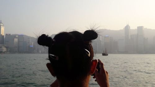 Rear view of man in city against clear sky