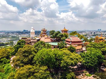 Panoramic view of trees and buildings against sky