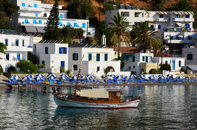 Boats moored in sea against buildings in city