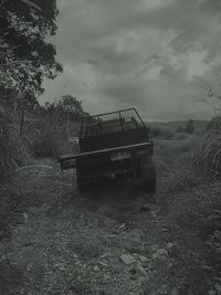 Abandoned truck on field against sky