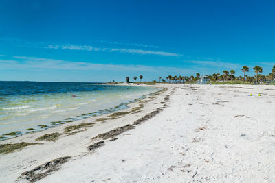 Scenic view of beach against blue sky