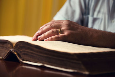 Midsection of man reading book