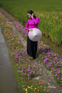 Woman standing on pink flowering plants