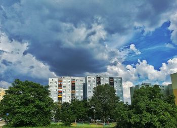 Low angle view of trees and buildings against sky