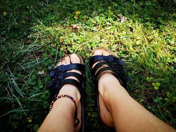 Low section of woman wearing shoes on field