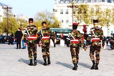 Rear view of army men walking on road