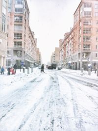 Snow covered city against sky