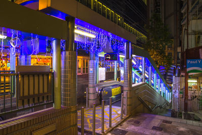 Illuminated street light by building in city at night