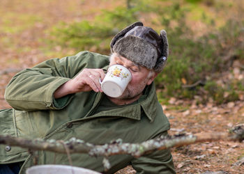Portrait of young man drinking coffee in park
