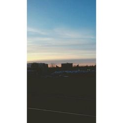 Buildings in city against sky during sunset