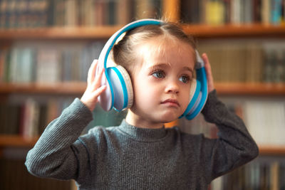 Close-up of girl wearing headphones at home