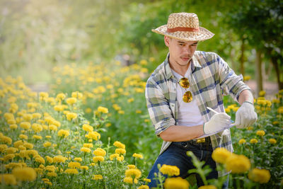 Full length of person standing on yellow flowering plants