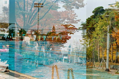 Swimming pool by trees against sky