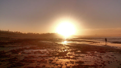 Scenic view of beach against sky during sunset