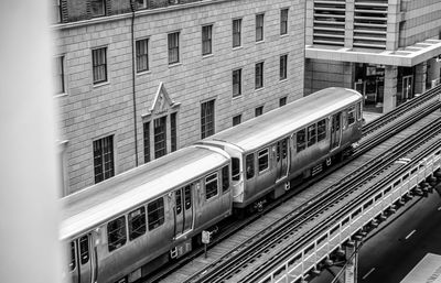 Train on railroad tracks by buildings in city