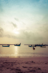 Boats on sea against sky during sunset