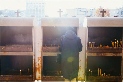 Rear view of woman with prayer candles