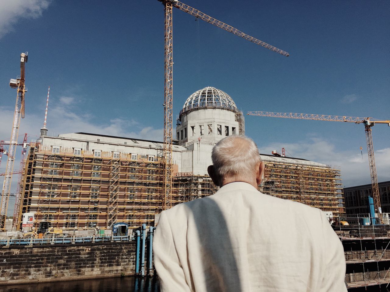 architecture, rear view, built structure, construction site, building exterior, real people, dome, day, senior adult, outdoors, men, sky, one person, city, people