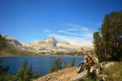 Scenic view of lake and mountains against blue sky
