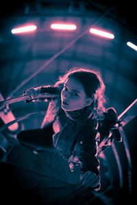 Midsection of woman with illuminated lights at night