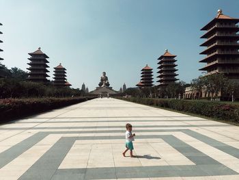 Toddler boy walking against temple