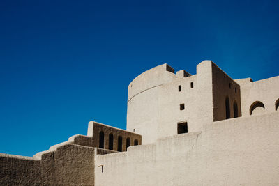 Low angle view of fort against clear blue sky