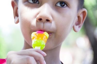 Close-up of boy eating candy