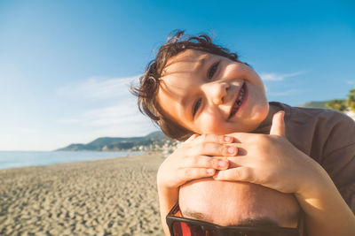 Boy sits on his father's shoulders