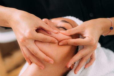Woman enjoying a professional ayurvedic facial massage with therapeutic essential oils