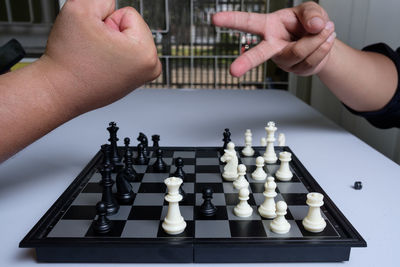 Cropped image of people playing on chess board