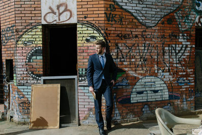 Man standing against graffiti wall