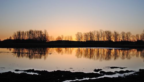 Scenic view of lake against sky at sunset