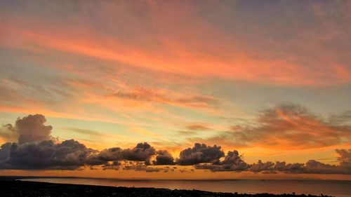 Scenic view of sea against dramatic sky during sunset