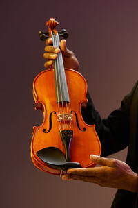 Midsection of man playing violin against white background