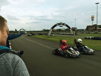 People riding motorcycle on road against sky