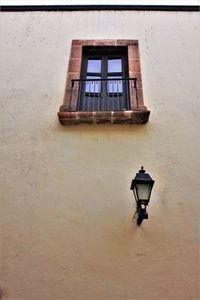 Low angle view of street light against building