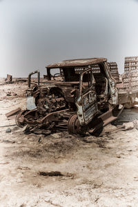 Abandoned truck on field against sky