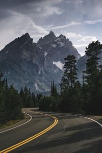 Road by trees against sky