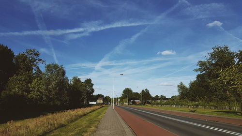 Road amidst trees against sky