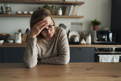 Side view of young woman sitting at home