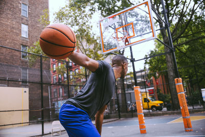 Man playing with basketball hoop