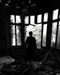 Silhouette of man standing on window