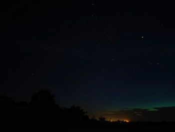 Low angle view of silhouette trees against sky at night